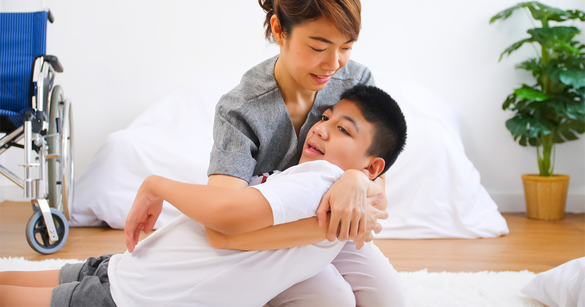 Caregivers for children with disabilities helping support structured developmental routines at home