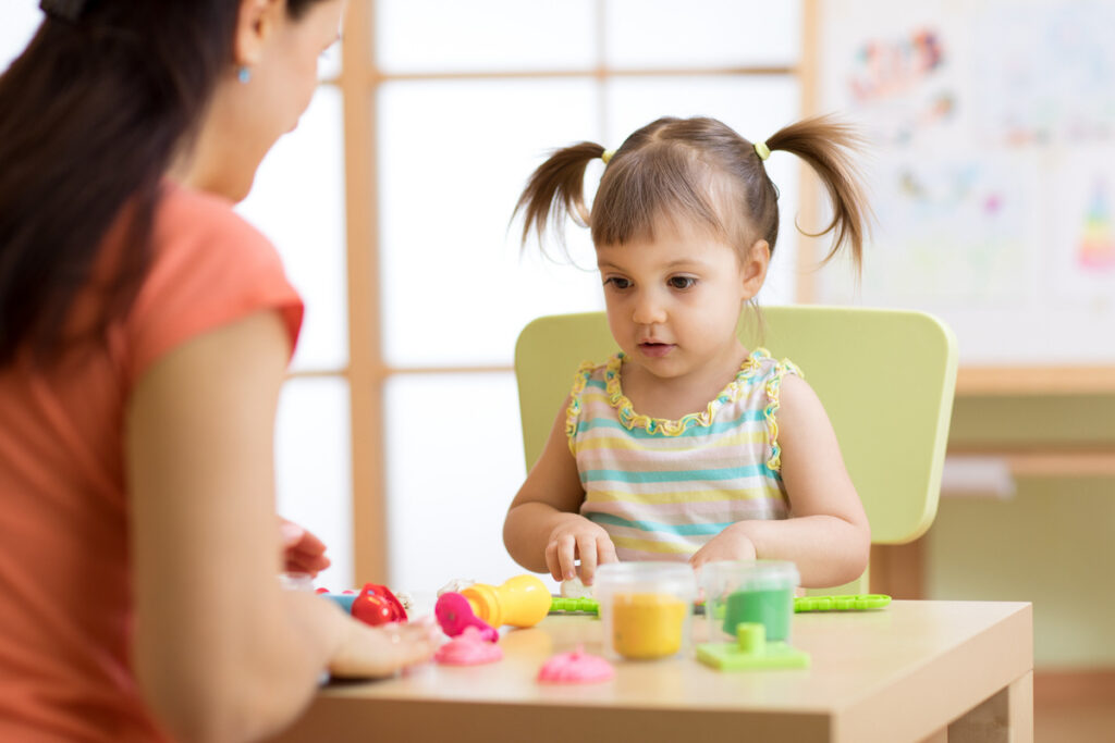 Caregiver working with a child with Down syndrome through the OPWDD program in the Bronx NY during a structured in-home activity session